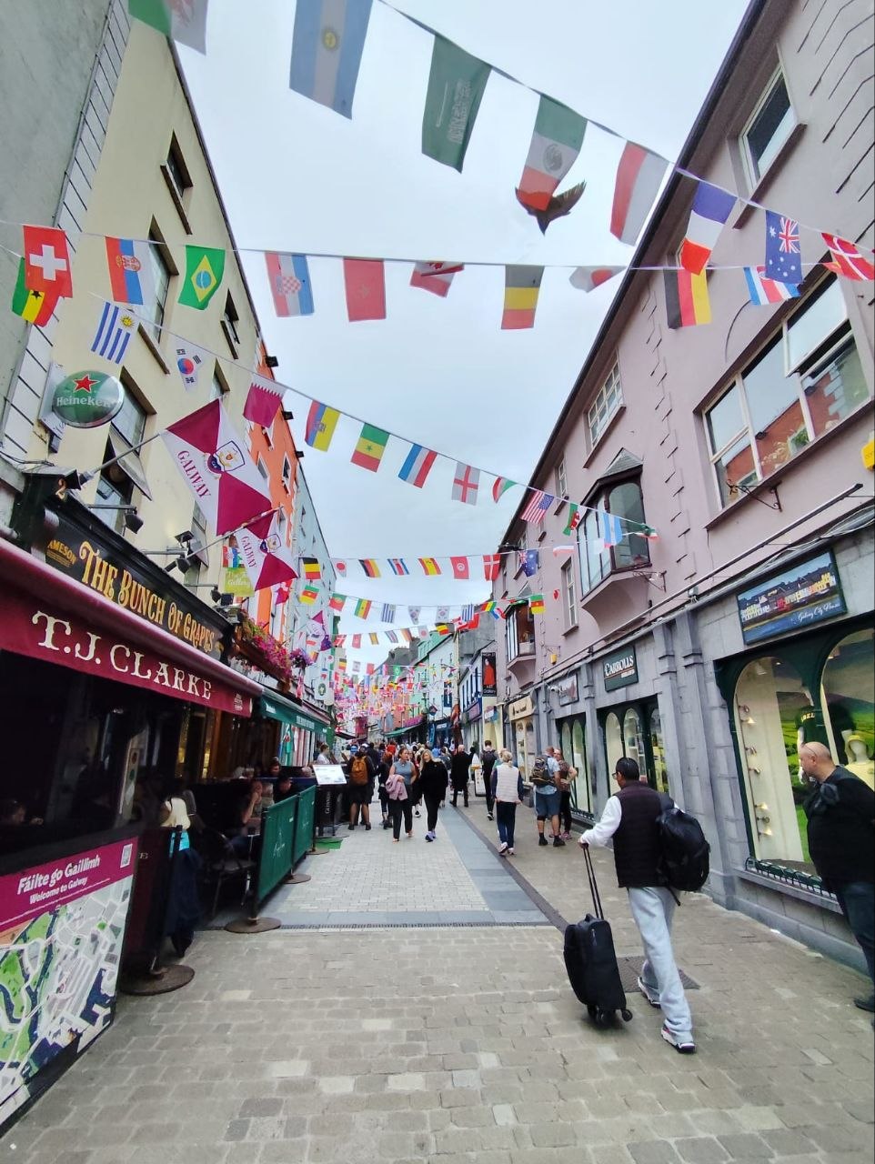 Calle céntrica de Galway decorada con banderas de países y pubs de piedra